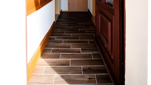 A hallway with a wooden door and a light switch on the wall. - Apartment '2' with Shared Terrace, Private Garden and Wi-Fi (Großräschen)