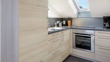 Een koelkast, een oven, een kookplaat, een koffiezetapparaat/waterkoker