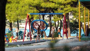 A playground with swings and a netted climbing structure. - Camp Adriatik (Primosten)