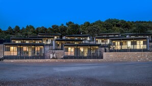 A modern multi-story building with large windows and a stone facade. - Camp Adriatik (Primosten)