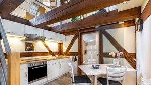 A modern kitchen with white cabinets, a black oven, and a wooden ceiling. - Holiday Home 'Oberlausitz With 160sqm' with Shared Terrace, Garden, and Wi-Fi (Cunewalde)