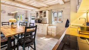 A wooden interior with a dining table, chairs, cabinets, and a kitchen area. - Holiday Home 'Oberlausitz With 160sqm' with Shared Terrace, Garden, and Wi-Fi (Cunewalde)