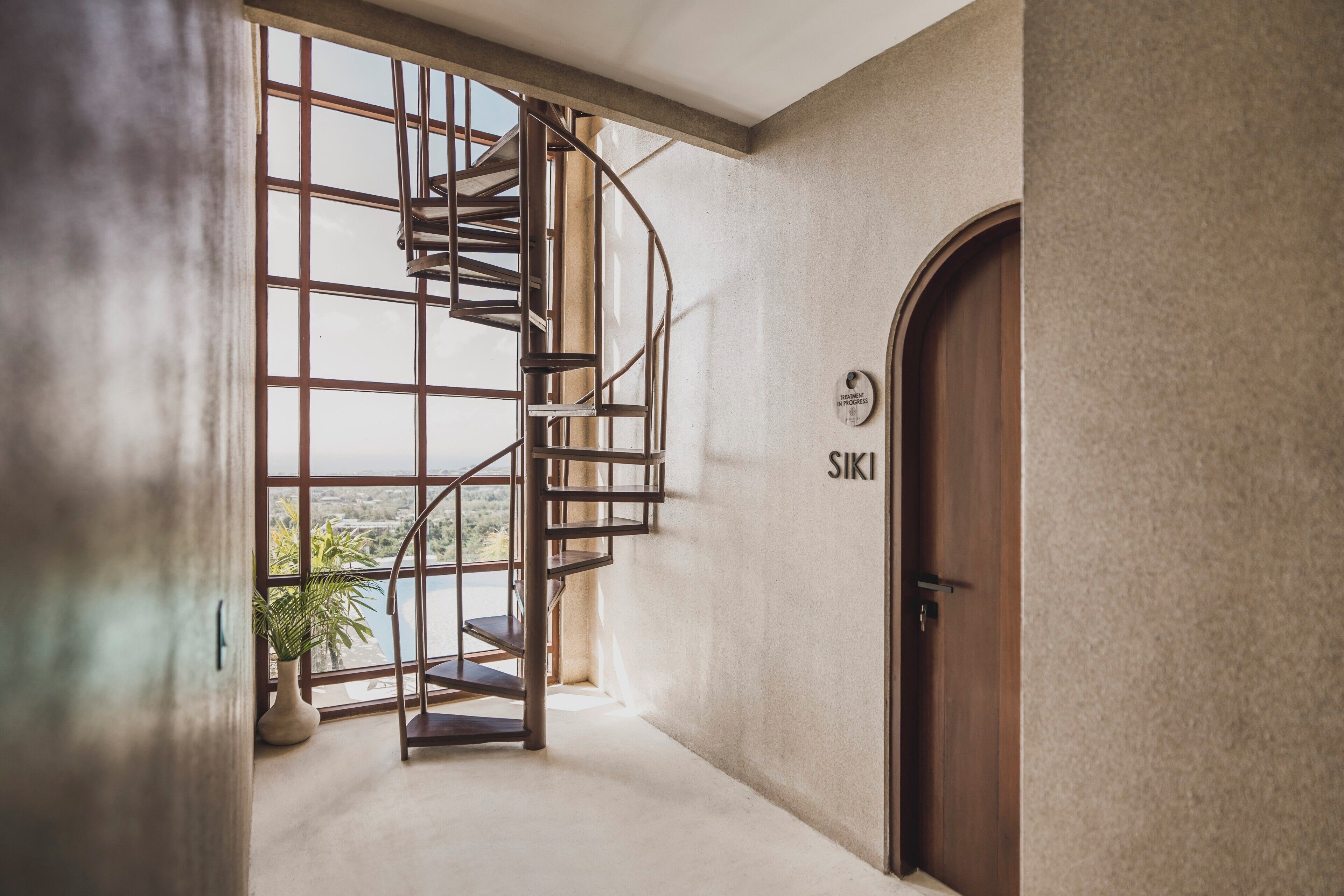 Una escalera en espiral que lleva a un balcón con vistas al exterior.