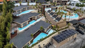 Un complexe hôtelier doté de plusieurs piscines, d’une architecture moderne et d’une végétation luxuriante.