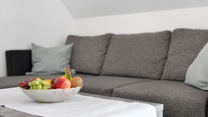 A bowl of fruit on a table in front of a grey sofa. - Apartment 'Birnau' with Lake View and Wi-Fi (Hagnau)