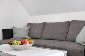 A bowl of fruit on a table in front of a grey sofa. - Apartment 'Birnau' with Lake View and Wi-Fi (Hagnau)