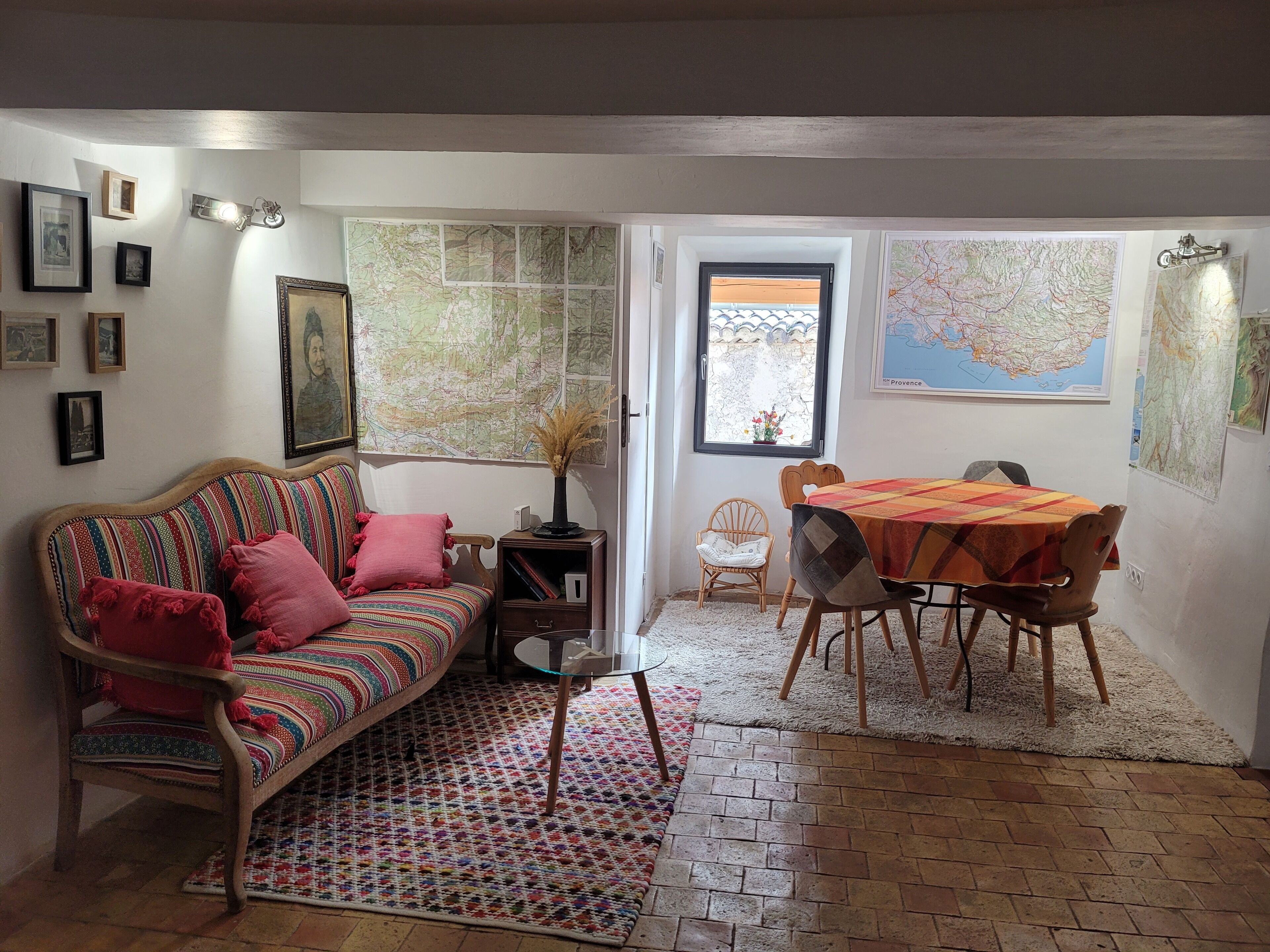 Un salon confortable avec un canapé, une table à manger et une fenêtre donnant sur un beau paysage.
