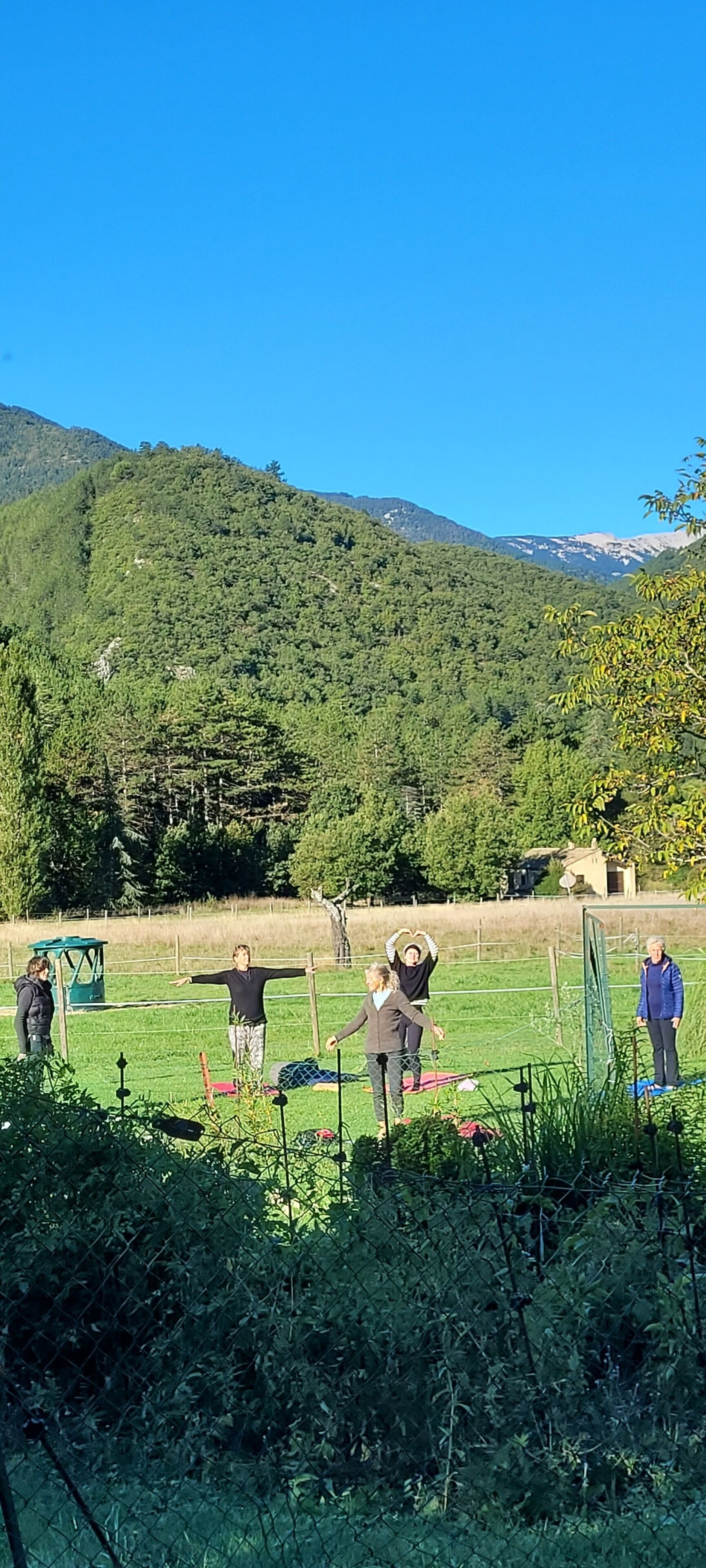 A group of people in an outdoor setting with a mountainous backdrop.