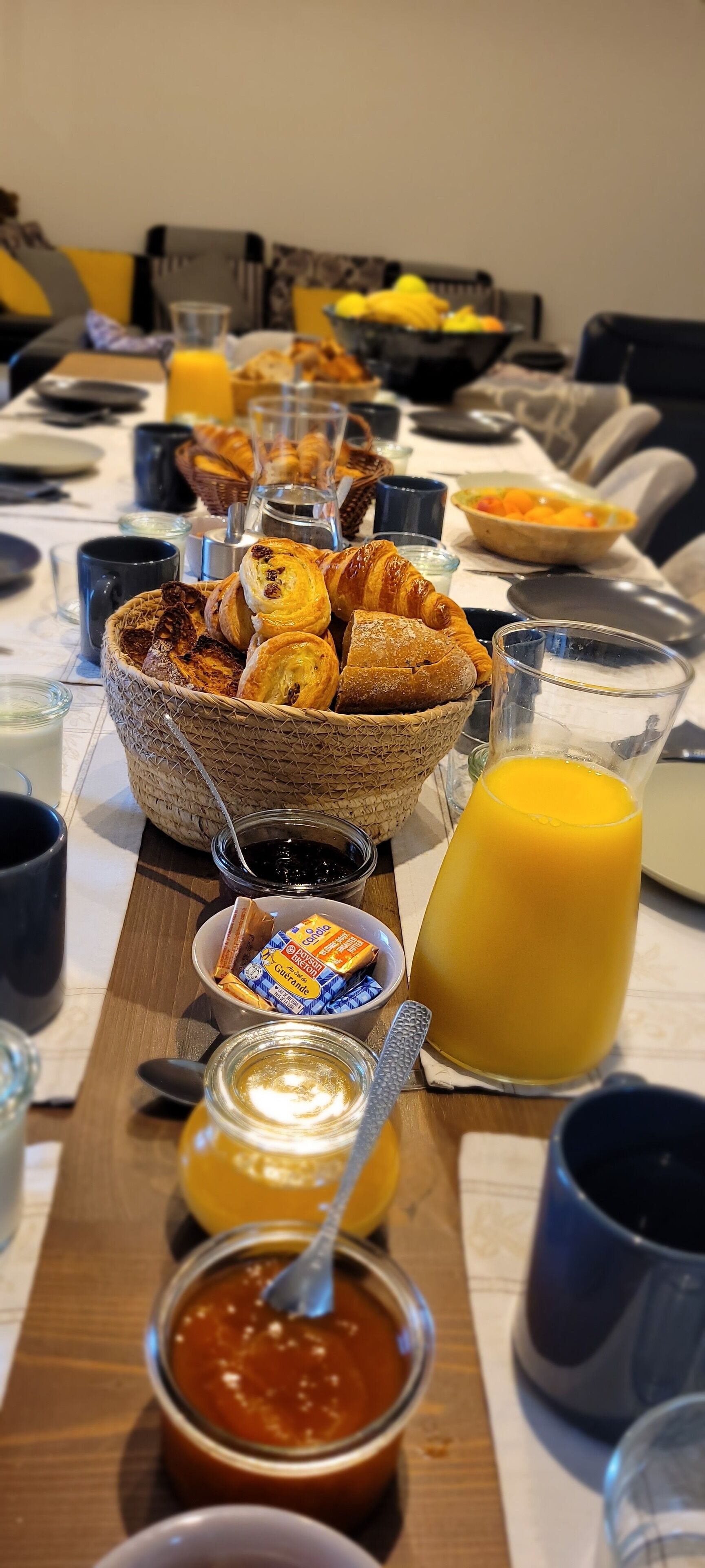 A breakfast buffet with pastries, juice, and condiments.