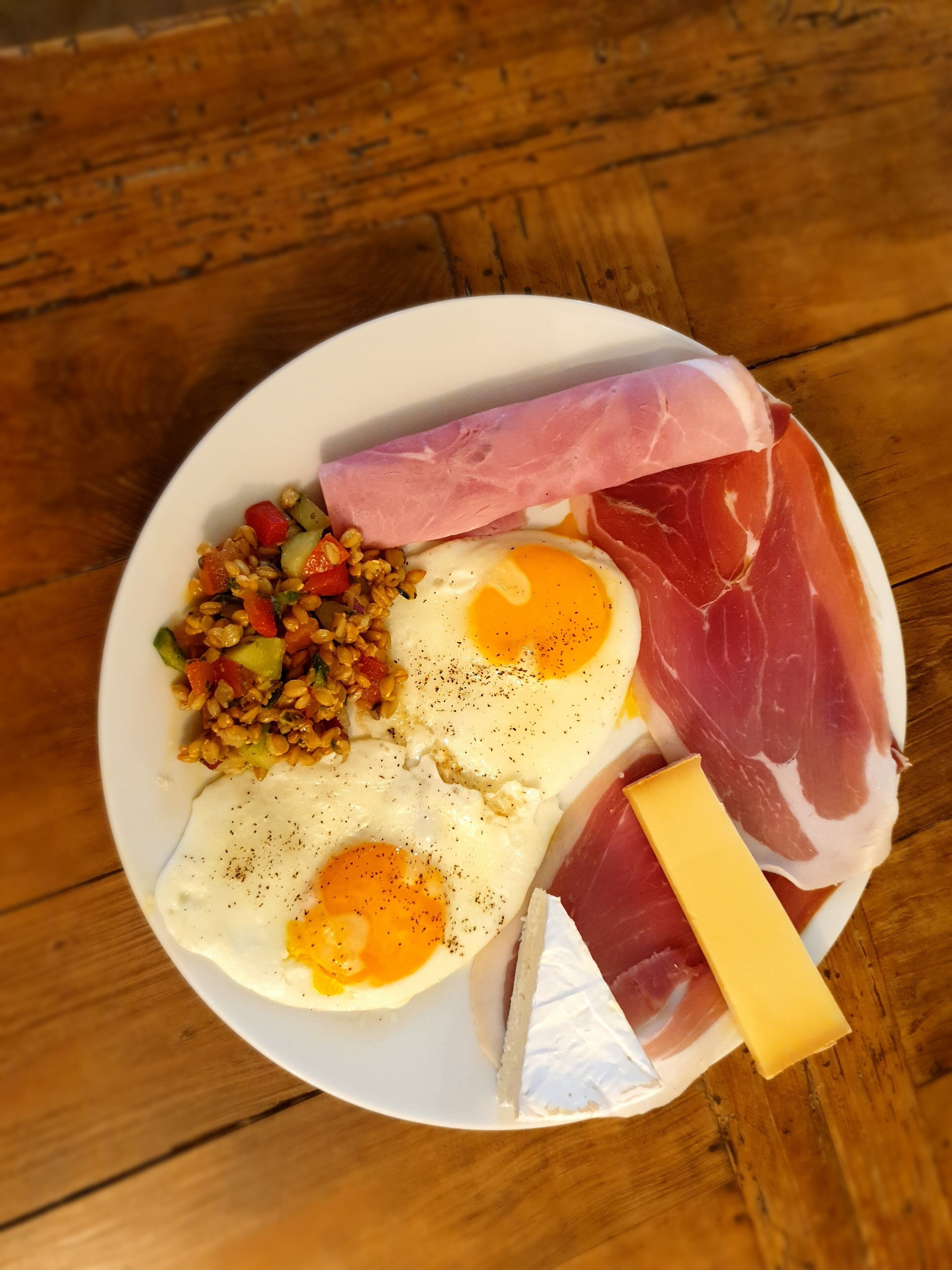 A plate with eggs, ham, cheese, and a vegetable mix.