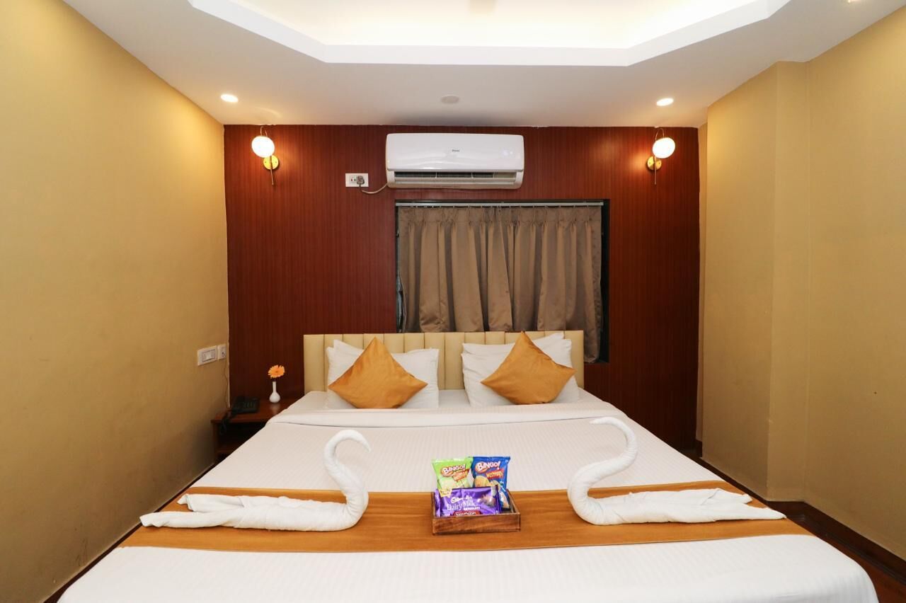 Ein Hotelzimmer mit Bett, Klimaanlage, Vorhängen und einem Tablett mit Snacks.