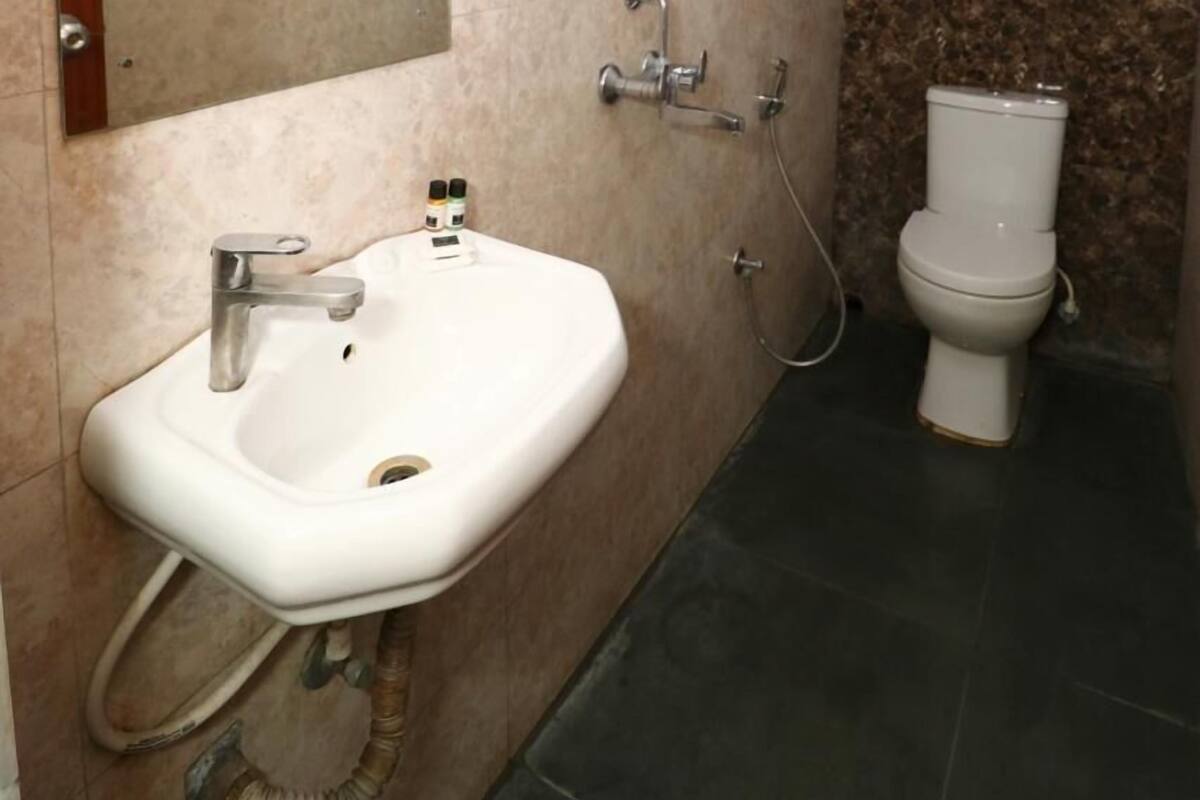 A bathroom with a sink, mirror, and toilet.