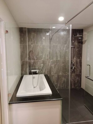 Bañera con ducha, artículos de tocador gratuitos, pantuflas, toallas