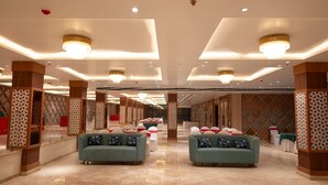 A spacious hotel lobby with a high ceiling, modern chandeliers, and a central seating area with sofas. - The Grand Royal Hotel (Samastipur)