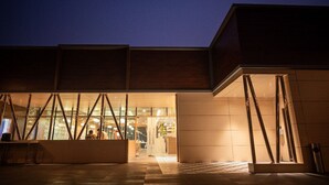 A modern building with a glass facade, a wooden exterior, and a well-lit entrance area. - The Grand Royal Hotel (Samastipur)