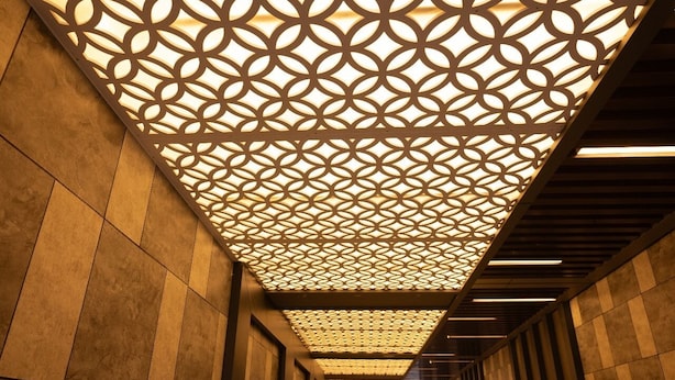 A corridor with patterned ceiling panels and a tiled floor. - The Grand Royal Hotel (Samastipur)