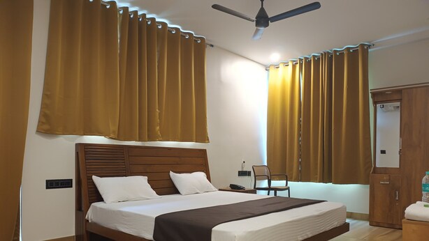 Ein Schlafzimmer mit einem hölzernen Bett, einem Deckenventilator und Vorhängen.