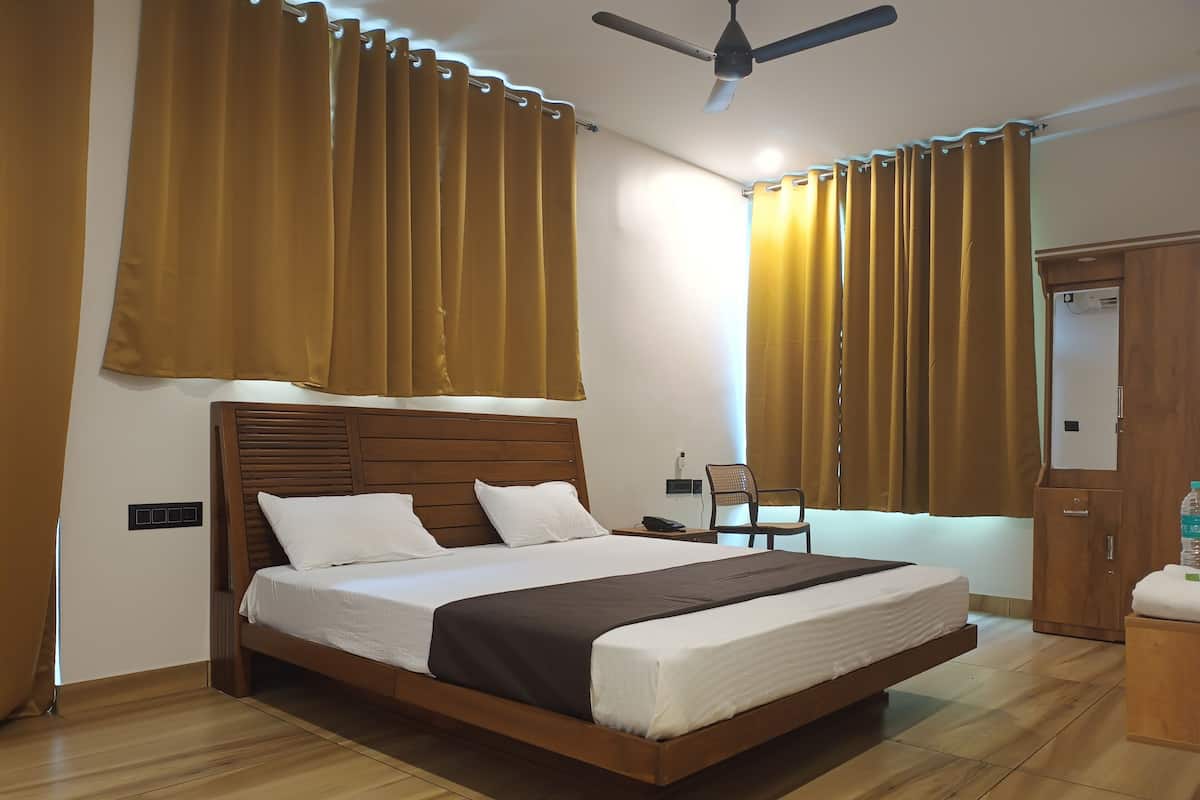 Un dormitorio con cama de madera, ventilador de techo y cortinas.