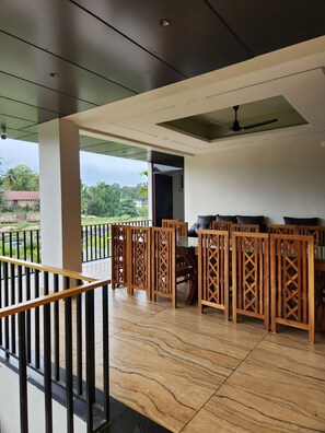 A modern interior with a balcony, wooden partitions, and a ceiling fan. - Falls Regency (Vilavancode)