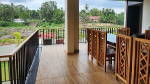 Ein Balkon mit Blick auf eine ländliche Landschaft, einschließlich Bäume und eines Gewässers.