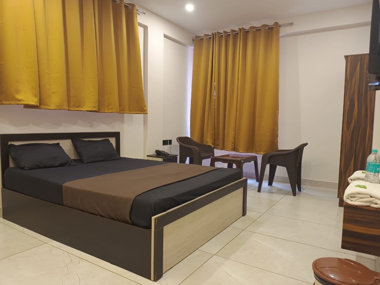 Ein Hotelzimmer mit Bett, Schreibtisch, Stuhl und Badezimmer.