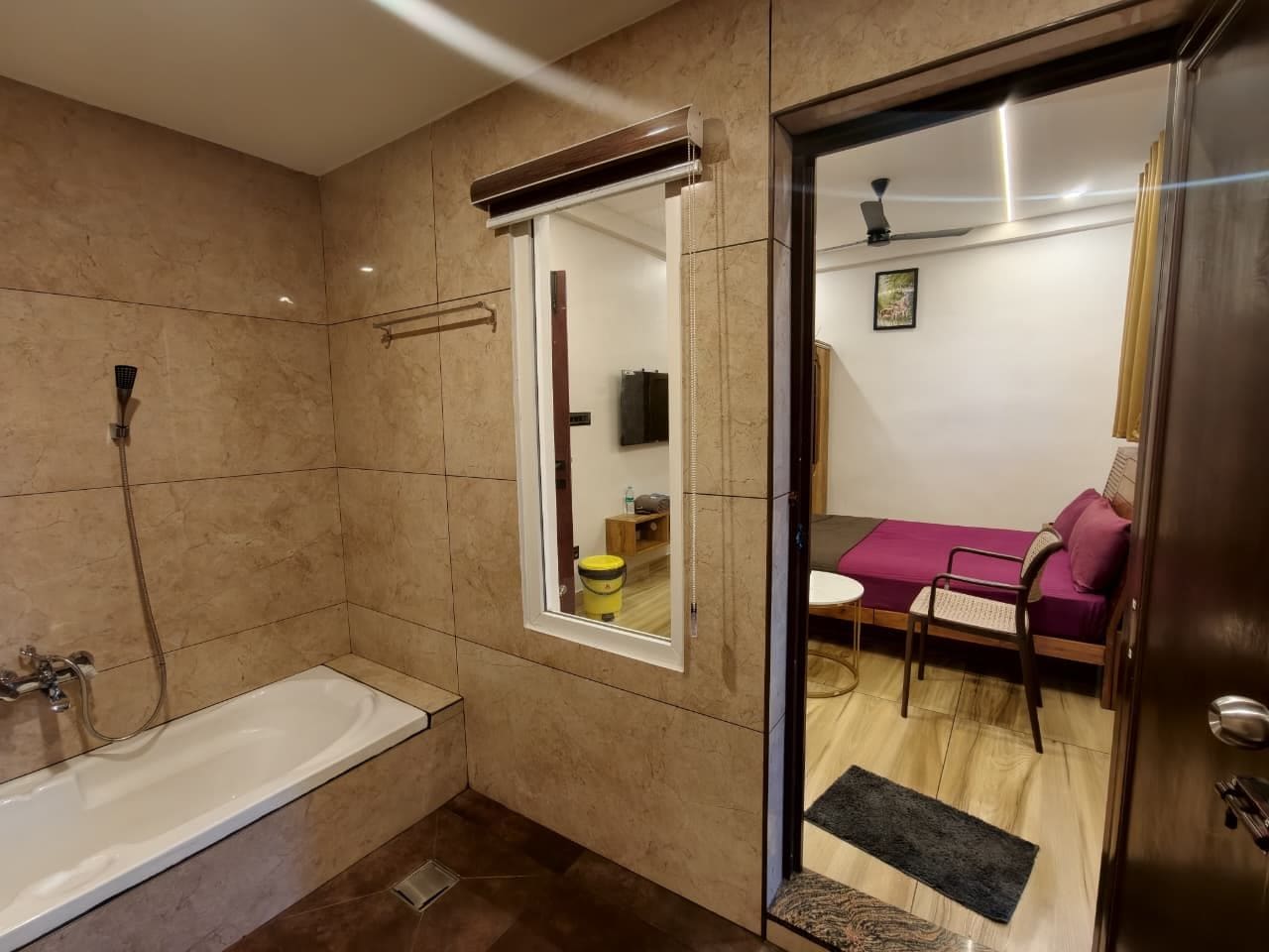 Un baño con bañera, ducha y ventana.