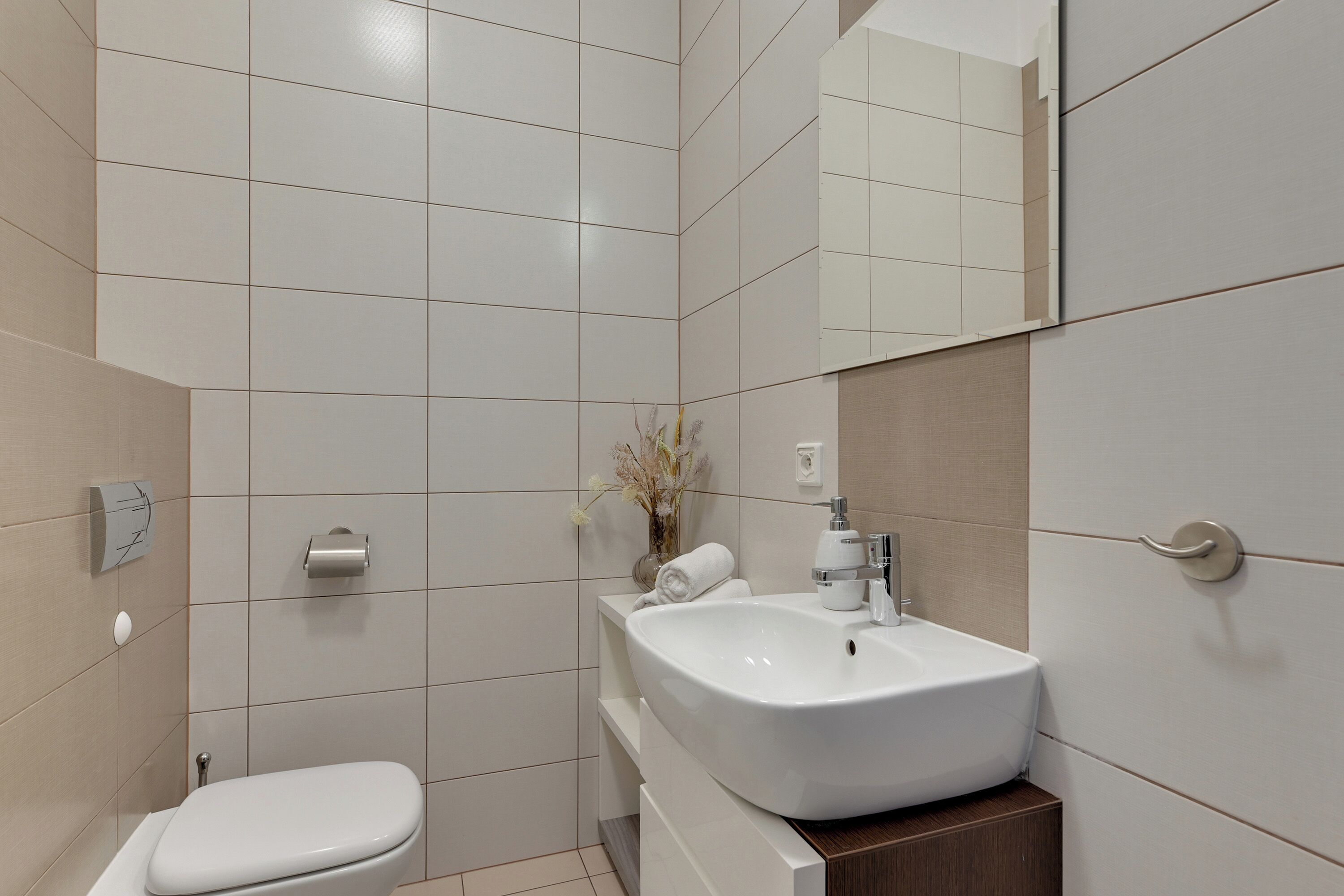Un bagno moderno con il water, un lavandino e uno specchio.