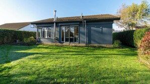 Una casa moderna con techo plano, ventanas amplias y una chimenea.
