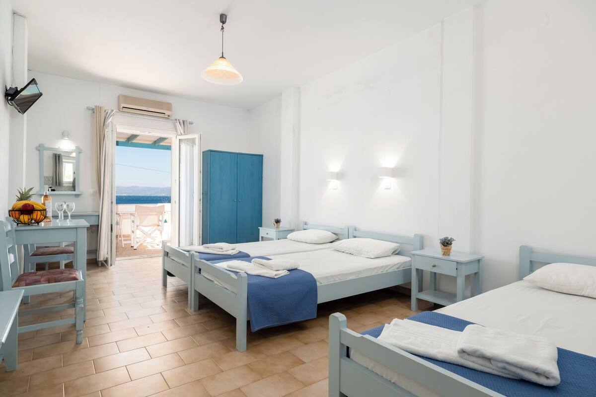 A bright, well-lit room with two beds, a desk, and a chair.