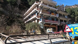 Un immeuble à plusieurs étages, doté de balcons et d’une enseigne indiquant que des chambres sont disponibles.