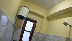 Une salle de bain avec des toilettes, une fenêtre, une douche et un lavabo.