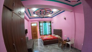 Une chambre à coucher comprenant un lit, un bureau, une chaise, une armoire et un plafond orné d’un motif circulaire.