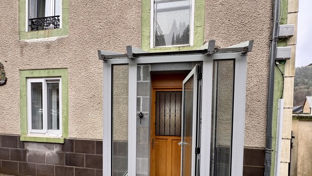 A small, enclosed entryway with a wooden door and a glass door, leading to a tiled entrance area. - Les Capucines Le Mont Dore 2pers (Mont-Dore)