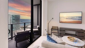A modern living room with a large window overlooking a cityscape and ocean view. - Best Stay - City Views, Gym & Pool (Miami)