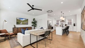 Un espacio moderno y abierto que combina sala y comedor, con un sofá, mesa y sillas.