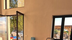 A modern kitchen with a central island, large windows, and a view of the outside. - Gavi - Renovated, beautiful former winery with great views! (Gavi)