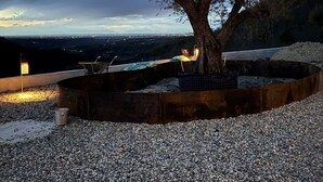 A tree in a circular planter with a gravel ground, surrounded by a metal railing. - Gavi - Renovated, beautiful former winery with great views! (Gavi)