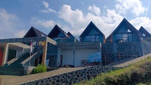 Una serie de edificios modernos, de diseño triangular y fachada de piedra, con una escalera que conduce a la entrada.