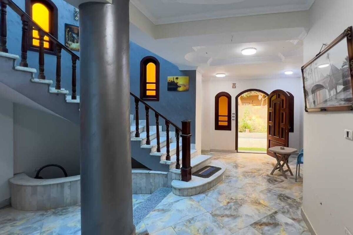 A staircase with a marble floor leading to a door with a glass panel.
