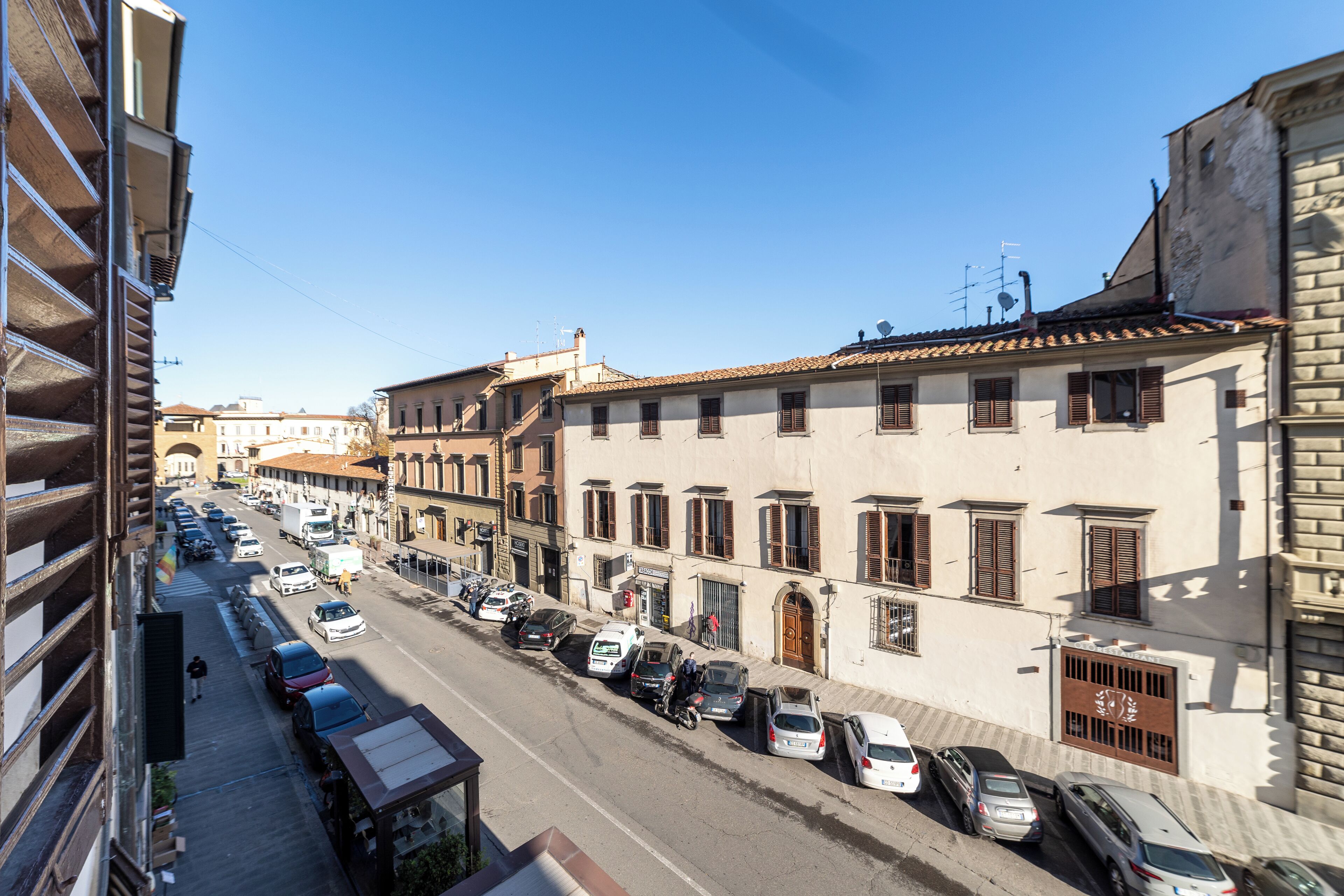 A street view with parked cars and buildings.