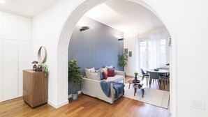 Een woonkamer met een bank, een salontafel en een eethoek met stoelen en een tafel.