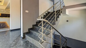 Una escalera moderna con barandilla metálica, escalones de mármol y un diseño interior limpio y minimalista.