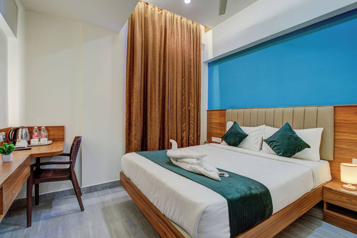 Une chambre d’hôtel avec un lit, un bureau et une chaise.