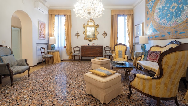 A spacious room with a large chandelier, ornate furniture, and a patterned floor. - Ca Lipoli (Venice)