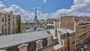 A high-rise building with a view of the Eiffel Tower in the background. - Studio with panoramic view of the Eiffel Tower (Paris)