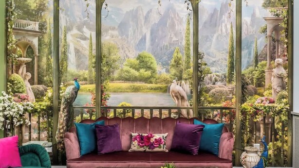 A cozy room with a large window, a plush sofa, and a wooden coffee table.