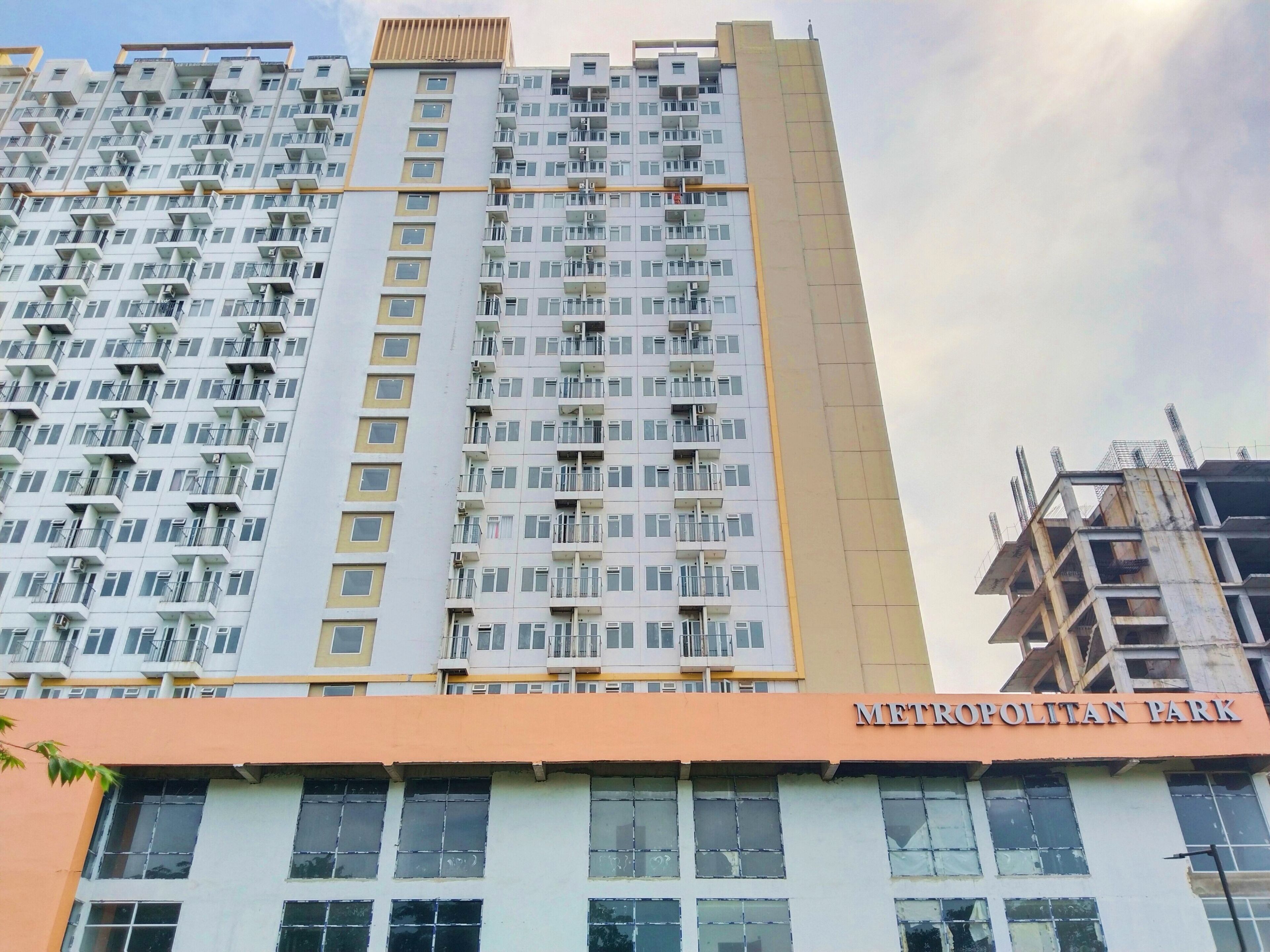 A high-rise building with multiple balconies and a sign reading "METROPOLITAN PARK".