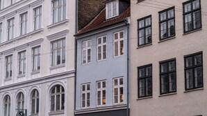 Eine Reihe mehrstöckiger Gebäude mit unterschiedlichen Baustilen, darunter Rundbogenfenster und verschiedene Fensterrahmen.