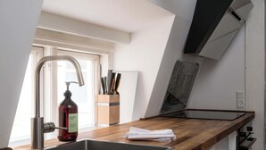Eine Küche mit modernem Wasserhahn, Holzarbeitsplatte und einem Fenster für natürliches Licht.