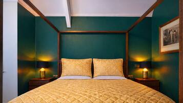 Een kamer met een groot bed, twee nachtkastjes en twee wandlampen.